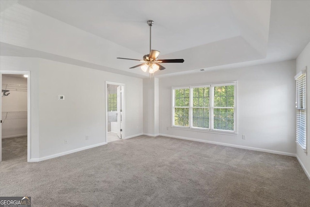 carpeted empty room with ceiling fan and baseboards