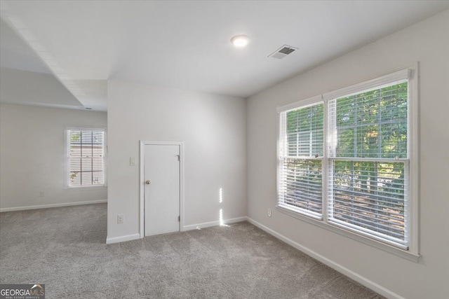 carpeted empty room featuring baseboards