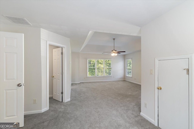 unfurnished room with carpet, ceiling fan, baseboards, and a raised ceiling