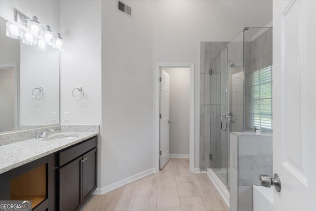 full bathroom with a shower stall, vanity, baseboards, and tile patterned flooring