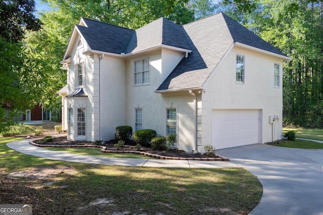 view of front of property with roof with shingles, a garage, concrete driveway, and stucco siding