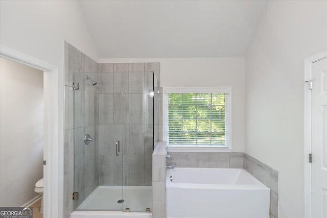 full bathroom with a stall shower, a garden tub, toilet, and vaulted ceiling