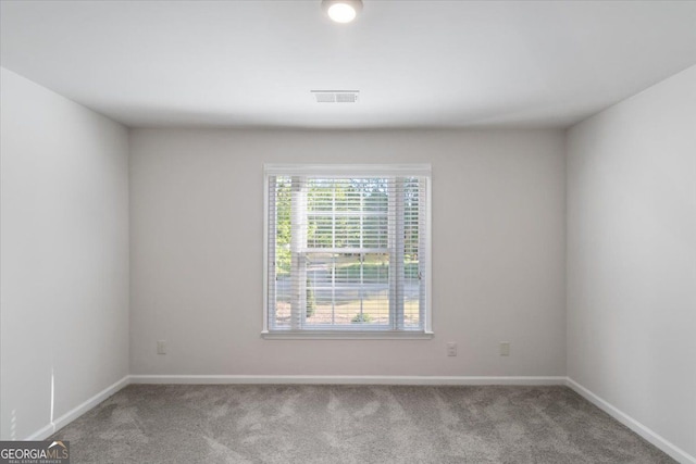 unfurnished room with carpet and baseboards