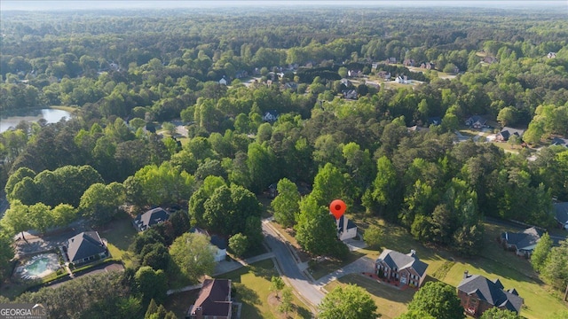 aerial overview of property's location featuring a heavily wooded area and a nearby body of water