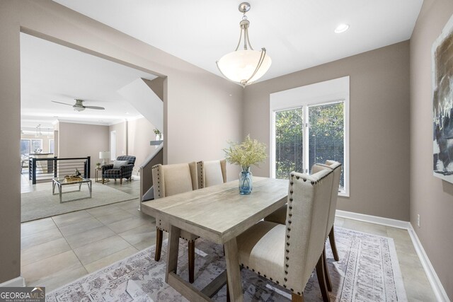 dining space featuring plenty of natural light, a ceiling fan, baseboards, and light tile patterned flooring