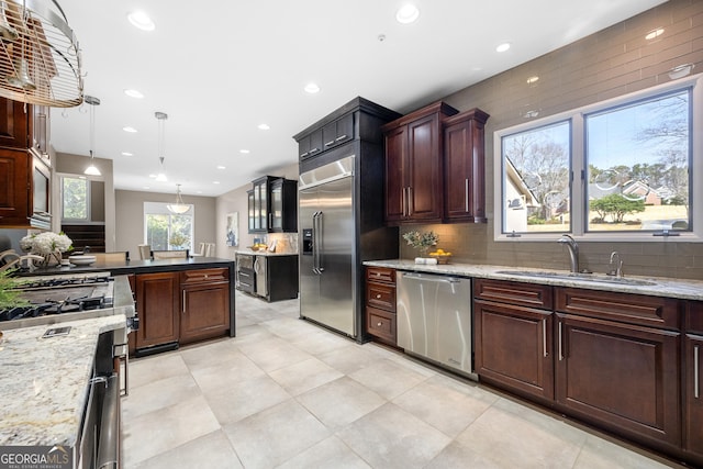 kitchen featuring a sink, hanging light fixtures, decorative backsplash, appliances with stainless steel finishes, and recessed lighting