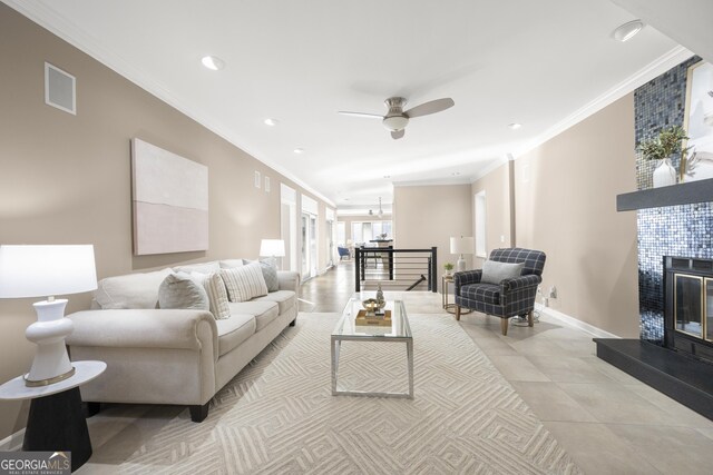 living area featuring recessed lighting, a tile fireplace, crown molding, baseboards, and ceiling fan