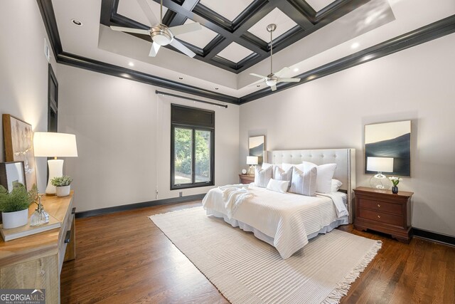 bedroom featuring coffered ceiling, wood finished floors, ornamental molding, beam ceiling, and baseboards