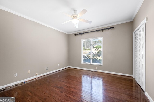 unfurnished bedroom featuring wood finished floors, ornamental molding, a closet, baseboards, and ceiling fan