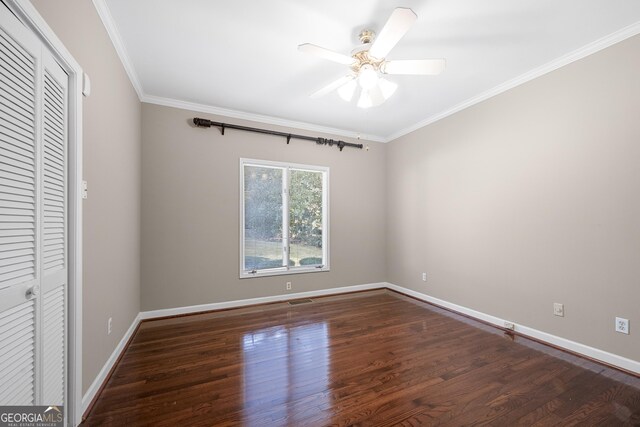 unfurnished bedroom featuring baseboards, a ceiling fan, wood finished floors, and crown molding