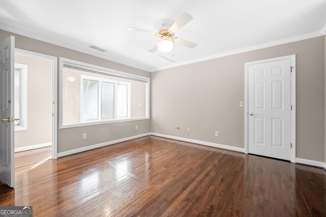 spare room featuring ornamental molding, baseboards, a ceiling fan, and visible vents