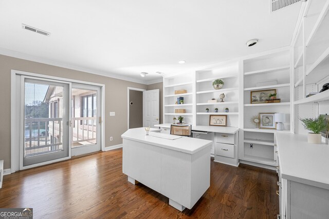 office featuring built in study area, dark wood-style flooring, ornamental molding, and visible vents