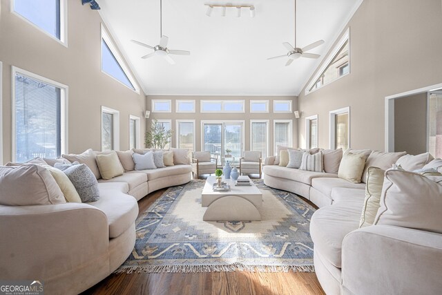 living area featuring plenty of natural light, a ceiling fan, and high vaulted ceiling