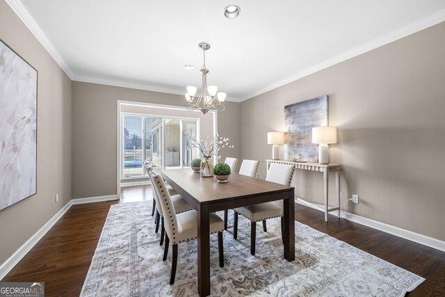 dining space featuring baseboards, a notable chandelier, and crown molding