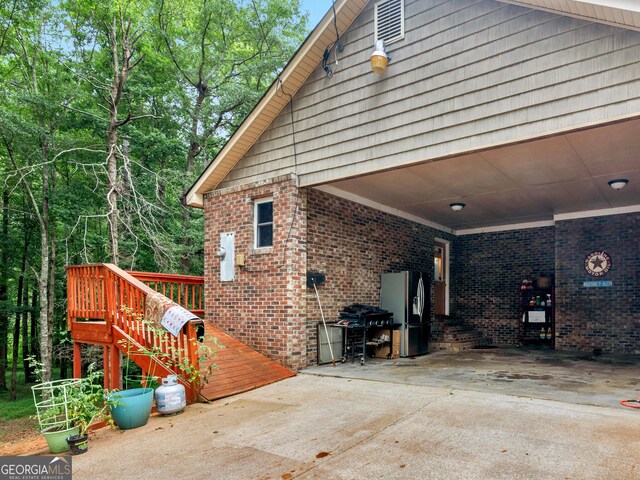 930 Singley Dr, Locust Grove, GA 30248 - view of side of home featuring stairway, concrete driveway, a wooden deck, a carport, and brick siding