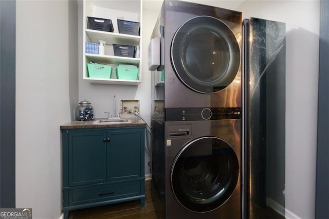 225 Nacoochee Dr, Woodstock, GA 30188 - clothes washing area featuring a sink, dark wood-style flooring, baseboards, stacked washer / dryer, and cabinet space