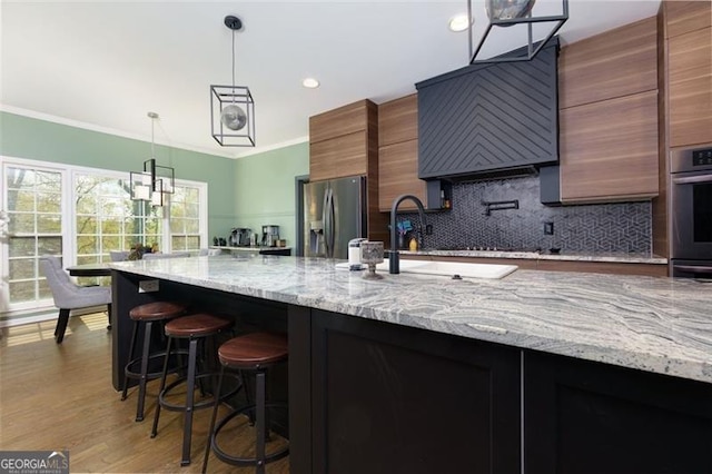 225 Nacoochee Dr, Woodstock, GA 30188 - kitchen with stainless steel appliances, a sink, backsplash, pendant lighting, and ornamental molding