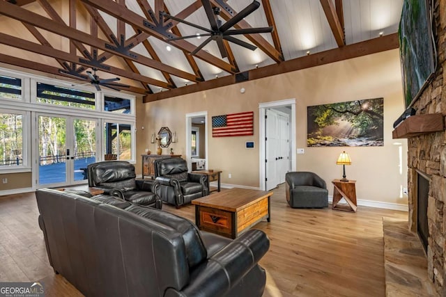 living room featuring wood finished floors, baseboards, a fireplace, high vaulted ceiling, and ceiling fan