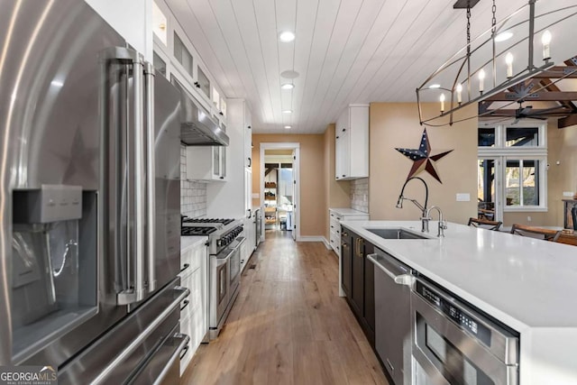 kitchen with light countertops, white cabinets, stainless steel appliances, and a sink