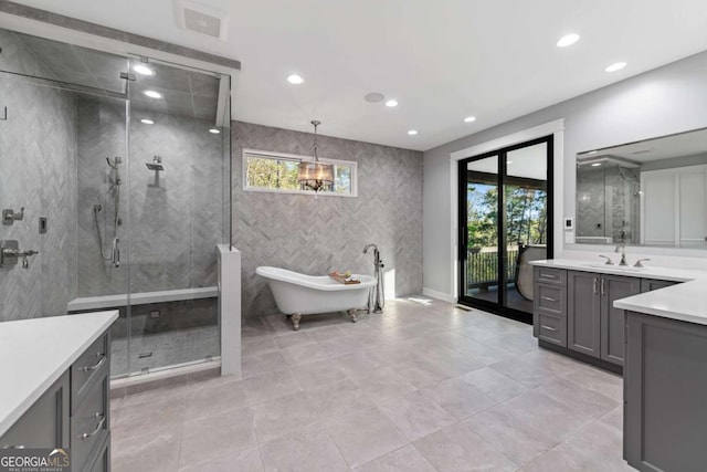 full bathroom with a shower stall, a soaking tub, vanity, and recessed lighting