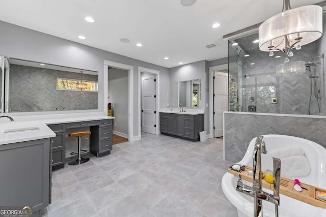 full bath featuring a sink, two vanities, recessed lighting, a freestanding tub, and a shower stall