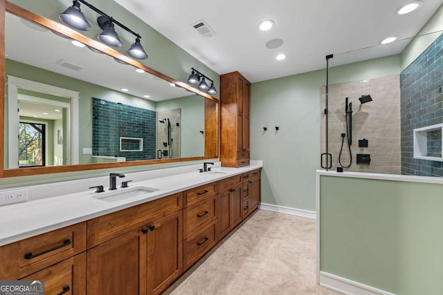 bathroom featuring visible vents, a sink, double vanity, and a tile shower