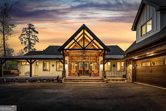 modern farmhouse style home with board and batten siding, a standing seam roof, and covered porch