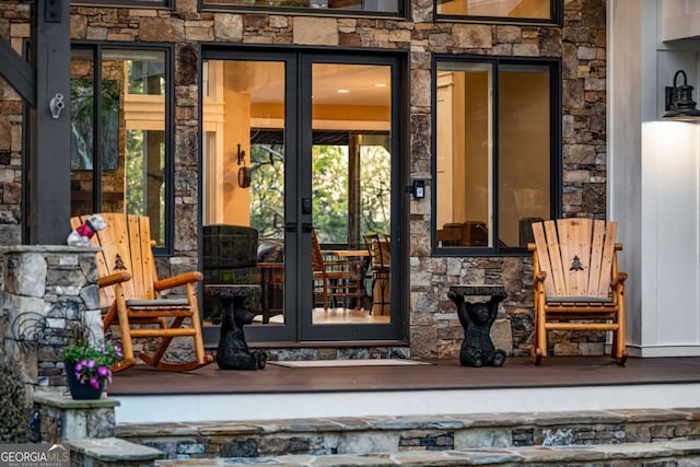 property entrance featuring stone siding and french doors