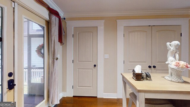 interior space with crown molding, baseboards, and dark wood-style flooring