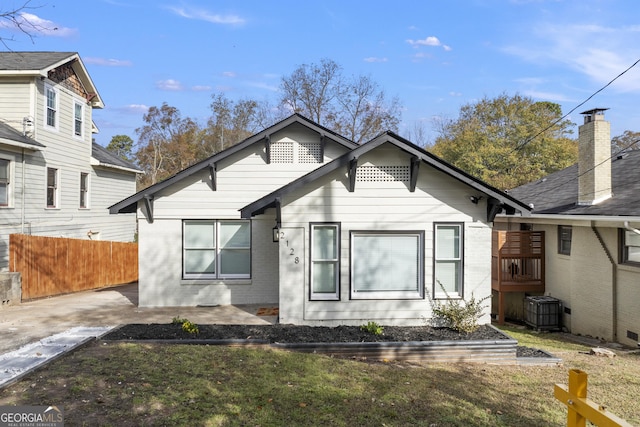 bungalow featuring fence, a patio area, brick siding, and central AC
