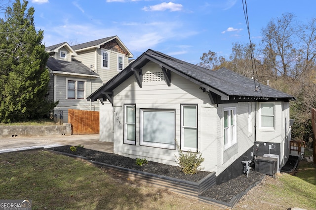 exterior space featuring roof with shingles and fence