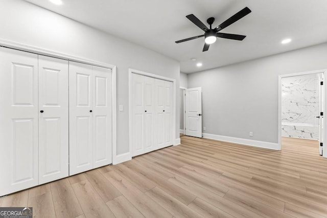 unfurnished bedroom with multiple closets, light wood finished floors, baseboards, ensuite bath, and recessed lighting