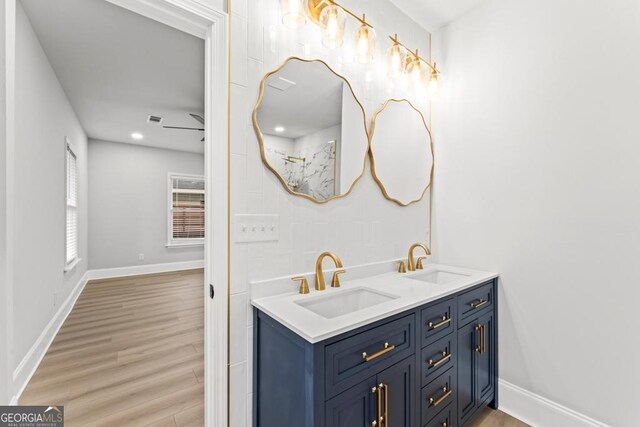 full bath with visible vents, wood finished floors, a sink, and double vanity