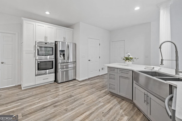 515 Old Chartwell Xing, Alpharetta, GA 30022 - kitchen with a sink, light wood-style floors, gray cabinets, stainless steel appliances, and recessed lighting