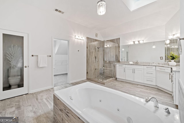 515 Old Chartwell Xing, Alpharetta, GA 30022 - bathroom with visible vents, vanity, a whirlpool tub, vaulted ceiling with skylight, and a stall shower