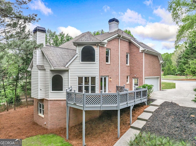 515 Old Chartwell Xing, Alpharetta, GA 30022 - rear view of property with a wooden deck, a chimney, brick siding, concrete driveway, and an attached garage
