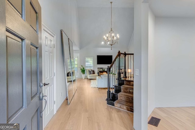 200 Piedmont Ave, Gainesville, GA 30501 - foyer featuring visible vents, an inviting chandelier, light wood-style floors, stairway, and high vaulted ceiling