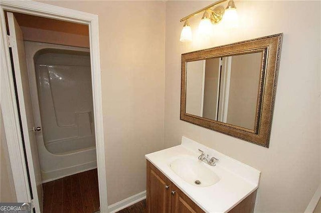 3540 Tarragon Dr, Decatur, GA 30034 - bathroom with baseboards, bathtub / shower combination, vanity, and wood finished floors