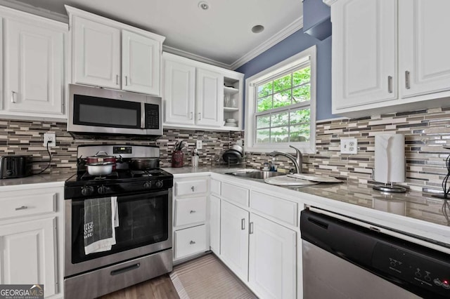 3999 Wabash Ln, Ellenwood, GA 30294 - kitchen featuring a sink, white cabinetry, appliances with stainless steel finishes, and crown molding