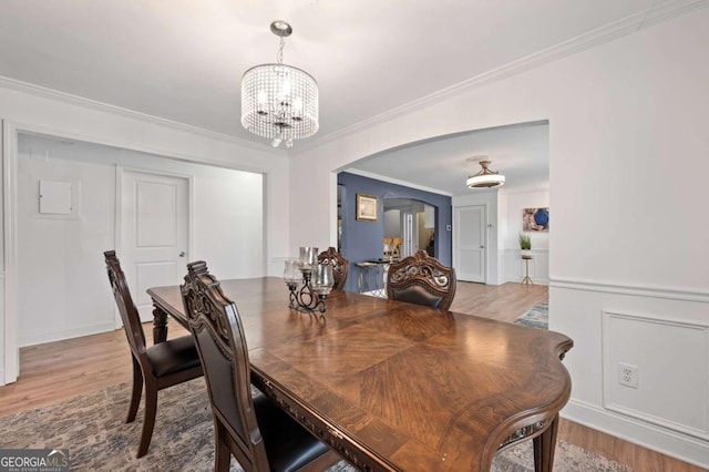 3999 Wabash Ln, Ellenwood, GA 30294 - dining area with an inviting chandelier, arched walkways, light wood-style floors, and crown molding