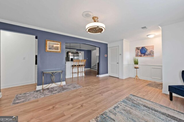 3999 Wabash Ln, Ellenwood, GA 30294 - living area featuring stairway, wood finished floors, arched walkways, ornamental molding, and visible vents