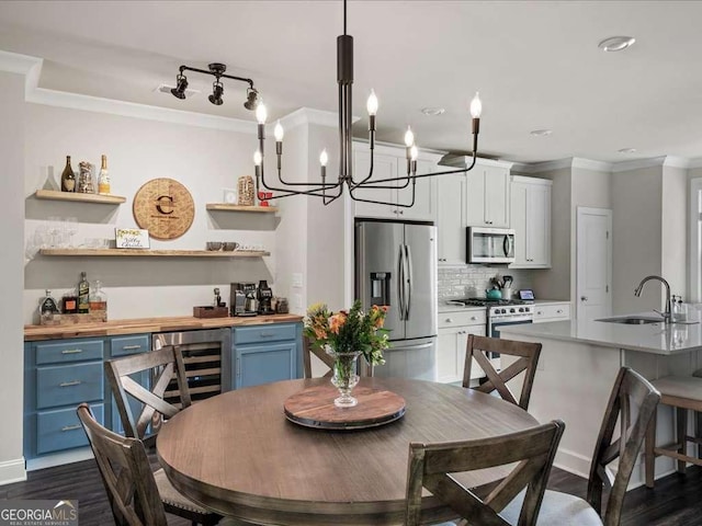dining area with dark wood finished floors, beverage cooler, an inviting chandelier, bar area, and crown molding