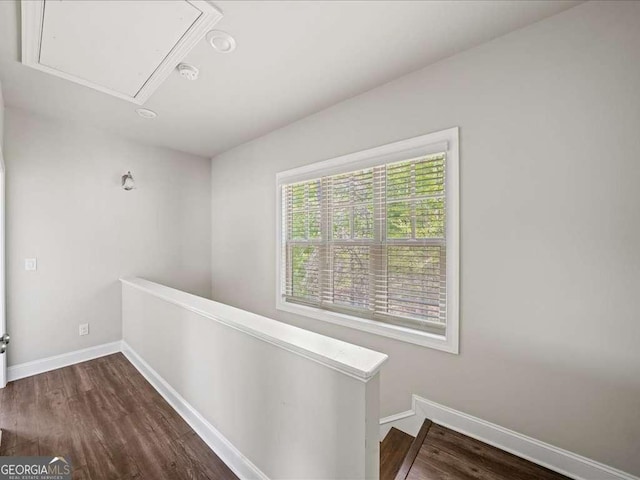 hall featuring attic access, baseboards, an upstairs landing, and dark wood finished floors