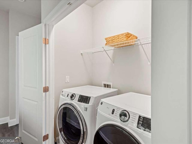washroom with dark wood-style floors, baseboards, washer and clothes dryer, and laundry area