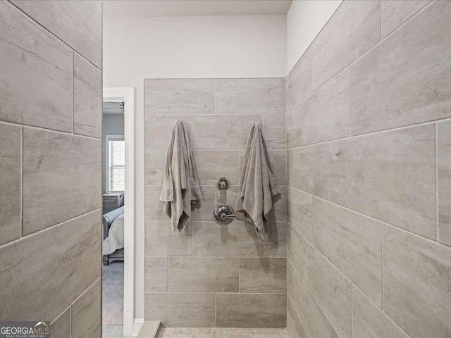 bathroom with a tile shower and ensuite bathroom