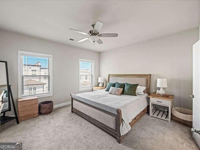 bedroom featuring visible vents, a ceiling fan, baseboards, and carpet floors