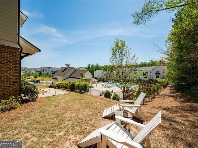 view of yard featuring a residential view, a fenced in pool, and fence