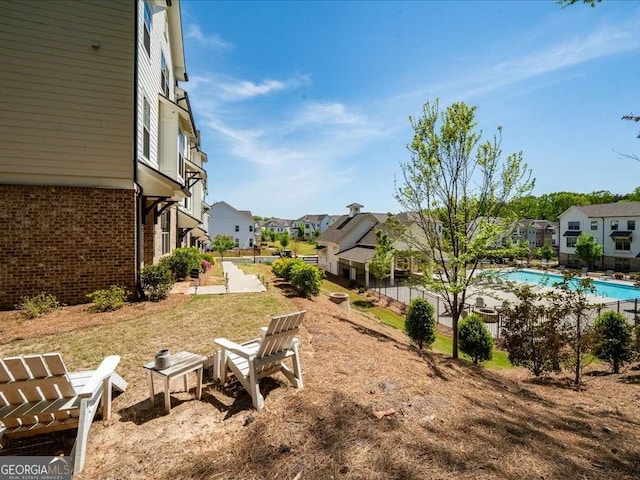 view of yard with a community pool and a residential view