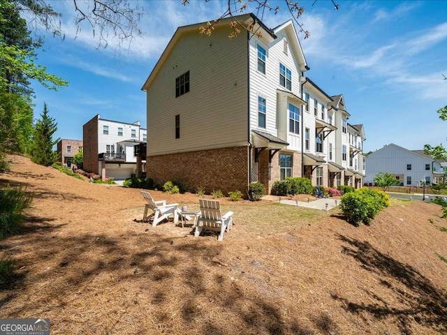 back of house featuring brick siding and a residential view