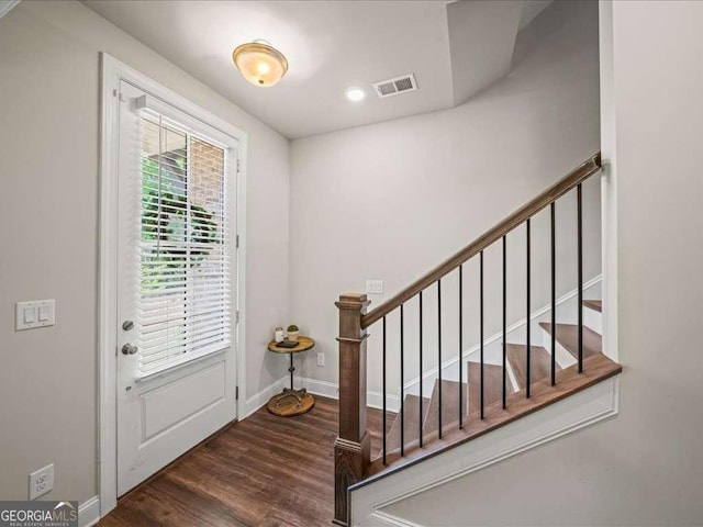 foyer entrance with wood finished floors, visible vents, baseboards, and stairs